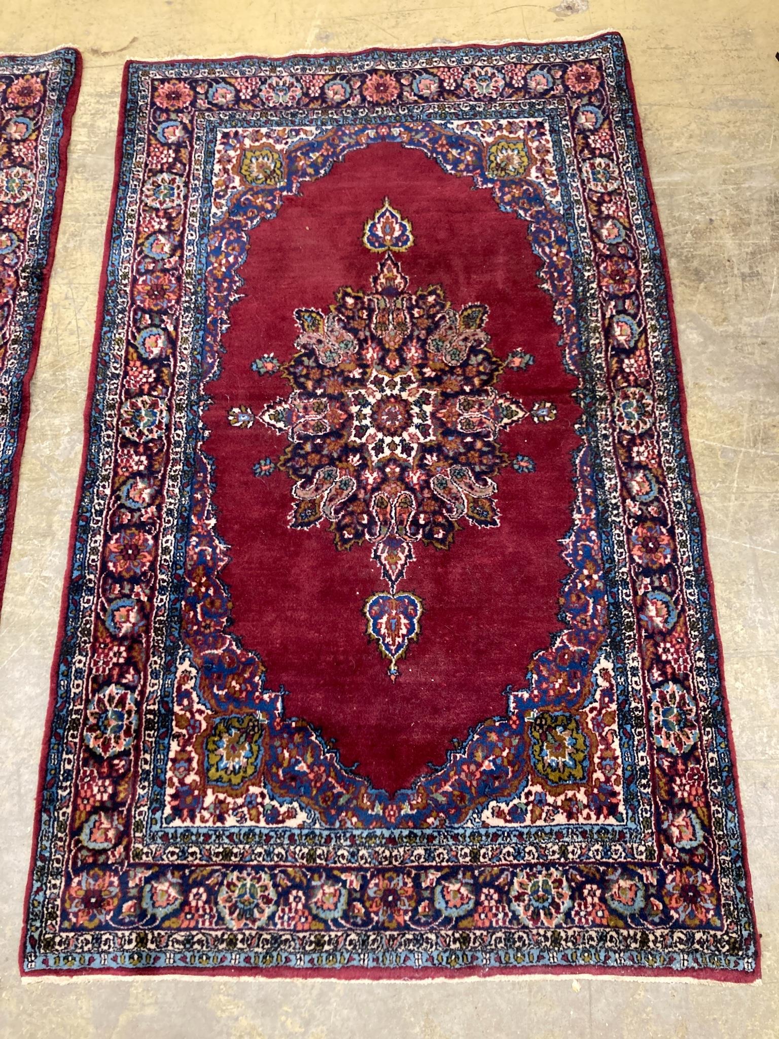 A pair of North West Persian burgundy ground rugs, 160 x 98cm